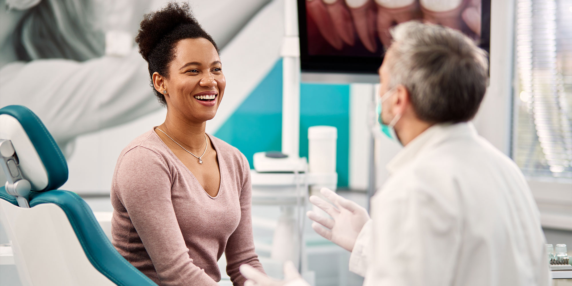 woman talking to her dentist during appointment at dental clinic.