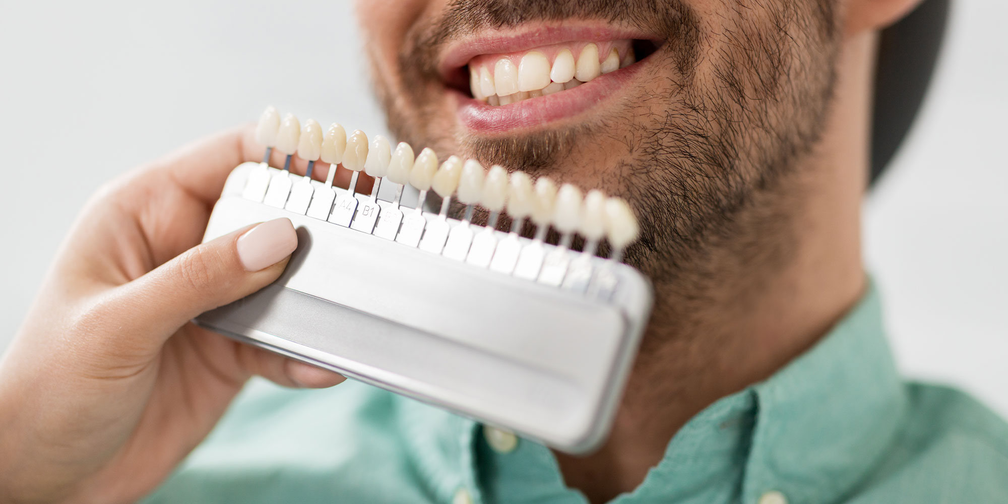 close up of dentist with veneer model comparisons