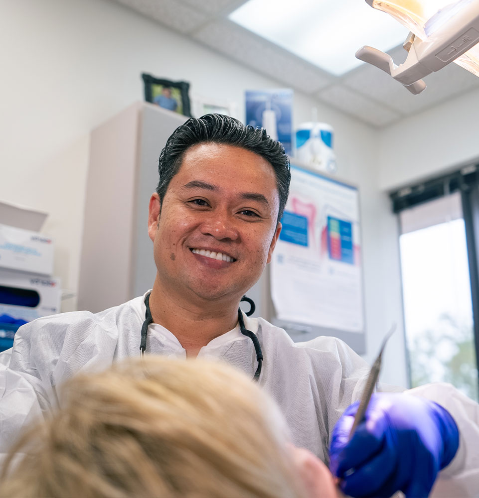 staff member performing a dental examination for their dental treatment