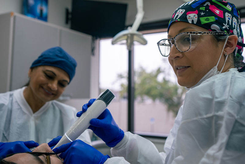 staff member performing examination on patient for their dental treatment
