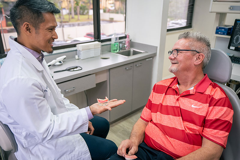 doctor showcasing a full arch dental model to patient